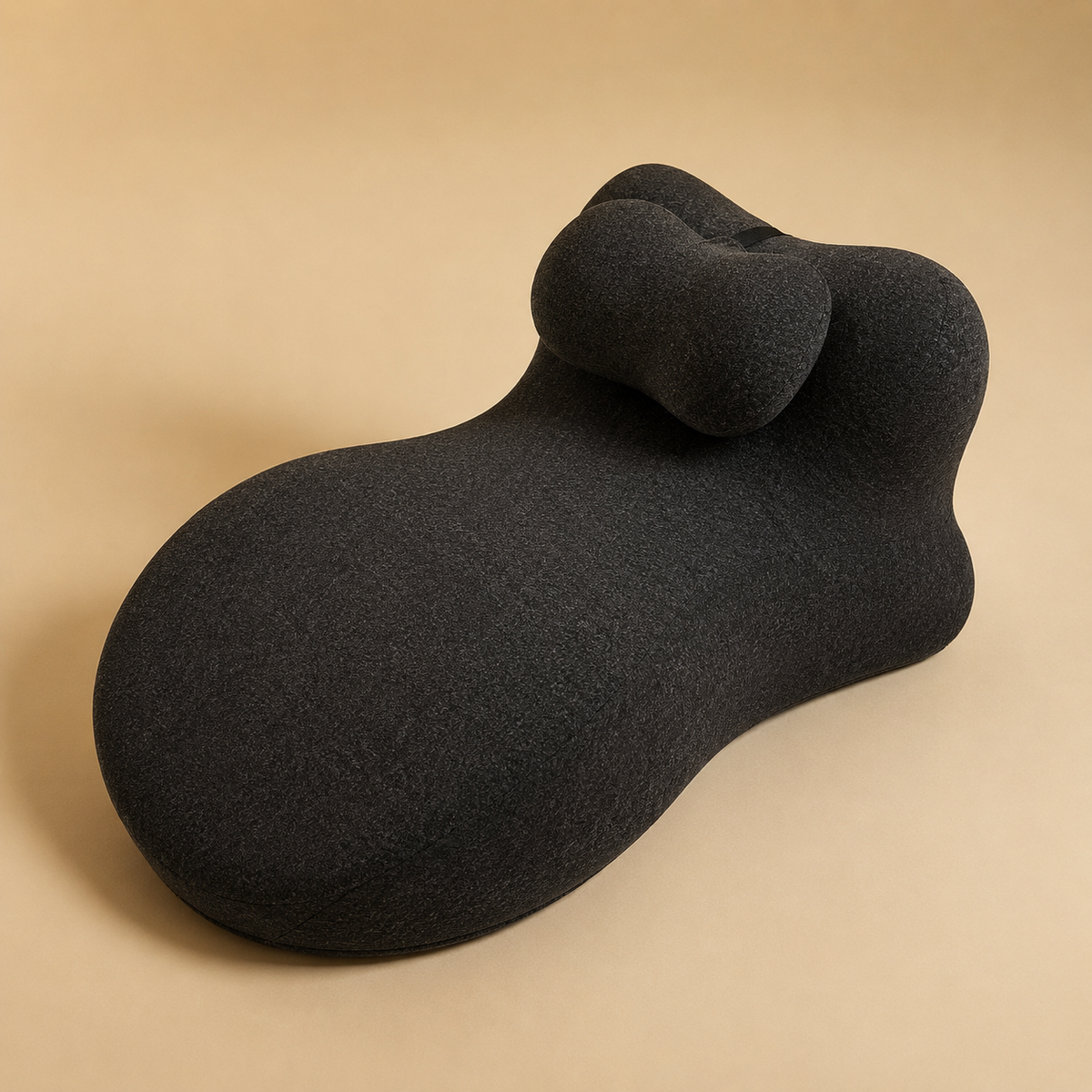 The Amoret Pillow Pro in charcoal on a soft sand backdrop