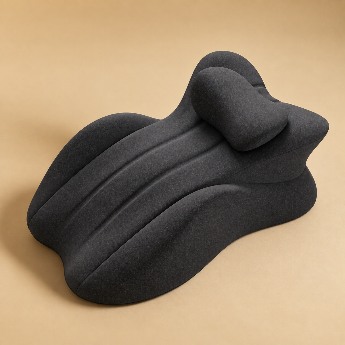The Amoret Pillow in charcoal on a soft sand backdrop